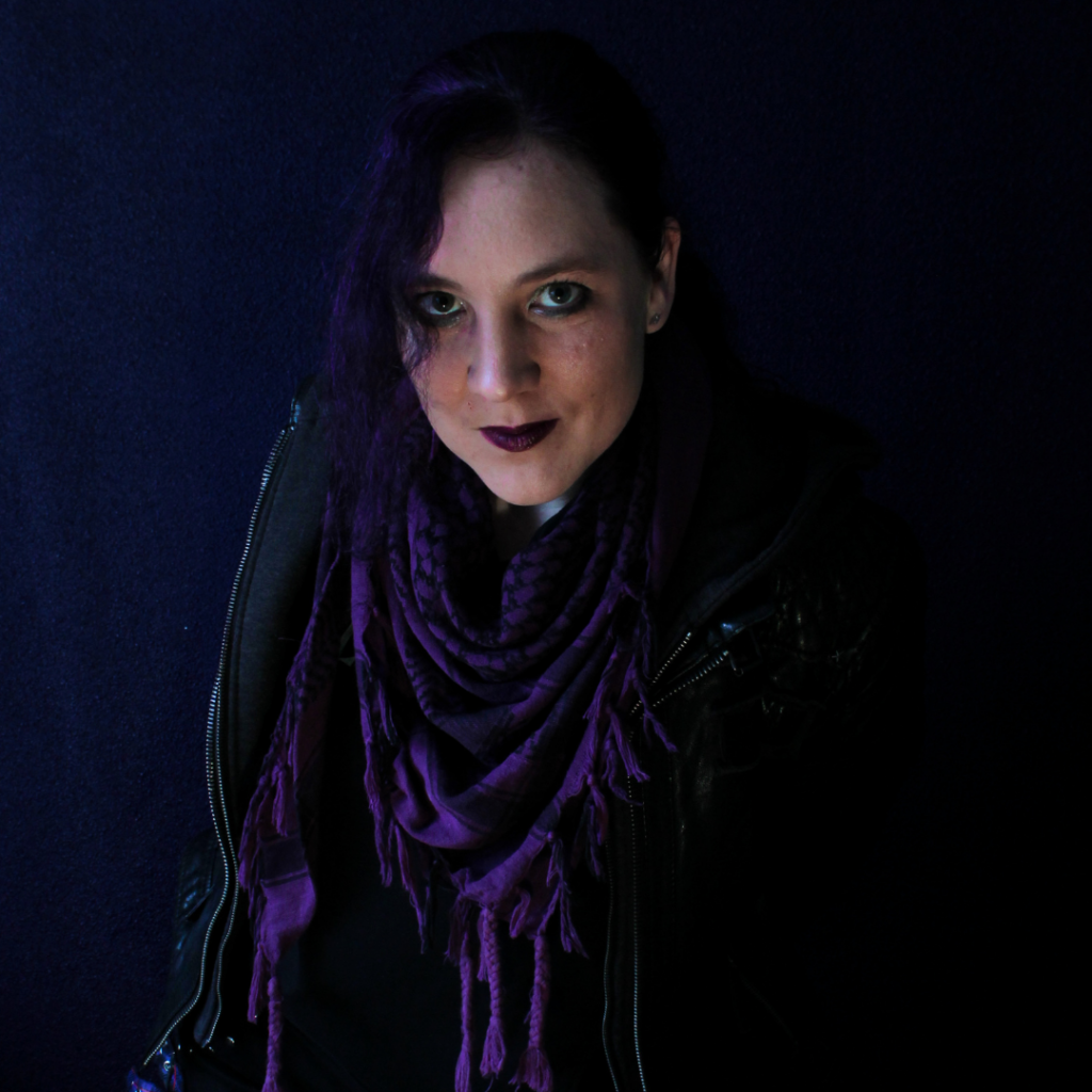 A selfportrait of Wianne wearing a purple scarf glaring into the camera.